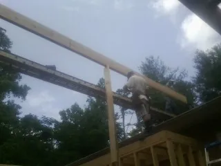 Carpenter setting a ridge beam over a new addition frame — Ice Dam Removal by Roofing Brothers in Royse City