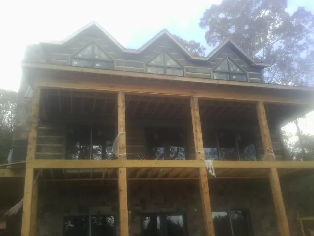 Dormers and porch framing on a large log home under construction — Roof Coating work by our crew in Royse City