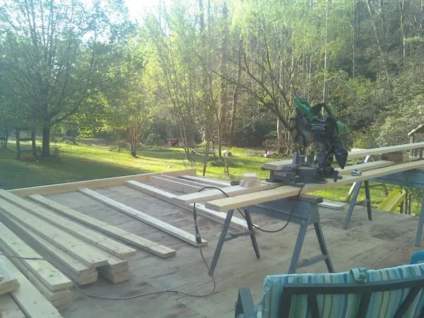 Miter saw and framing lumber on a deck under construction in Royse City
