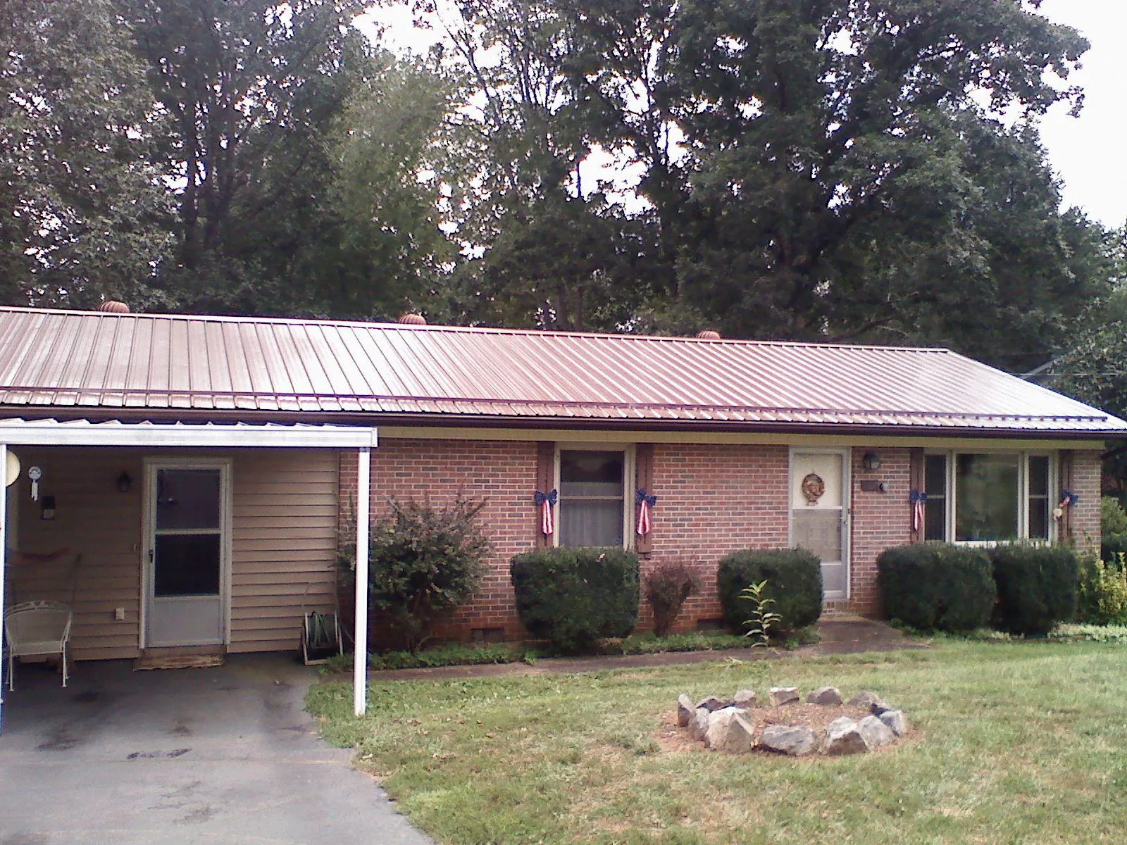 Bronze metal roof and carport on a brick ranch home — Roof Repair work by our crew in Royse City